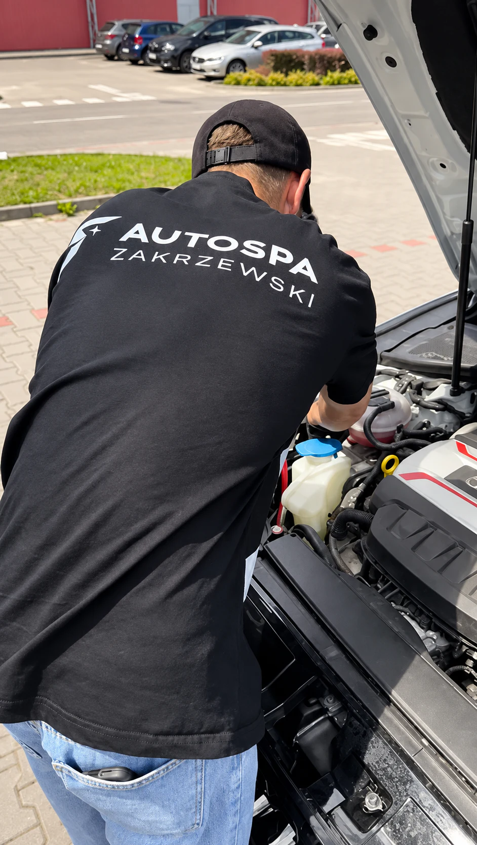Pracownik AutoSpa Zakrzewski podczas pracy przy samochodzie